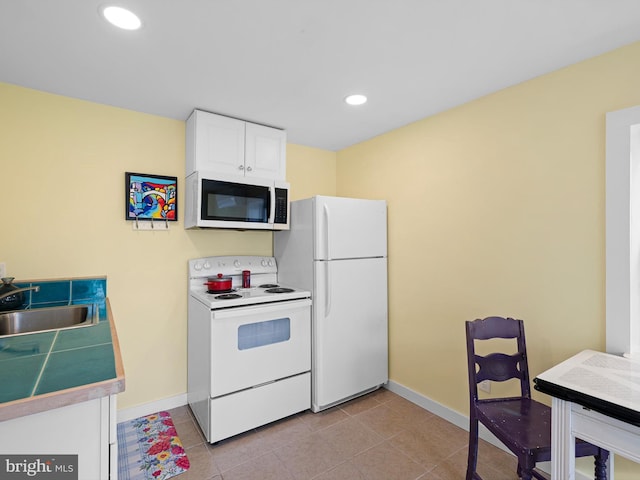 kitchen featuring white cabinets, white appliances, sink, and light tile patterned floors