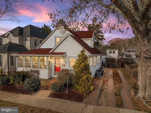 view of front of house with a sunroom and cooling unit