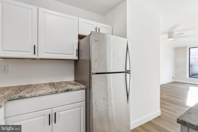 kitchen with ceiling fan, light hardwood / wood-style floors, white cabinetry, and stainless steel refrigerator