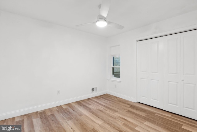 unfurnished bedroom featuring a closet, light hardwood / wood-style floors, and ceiling fan