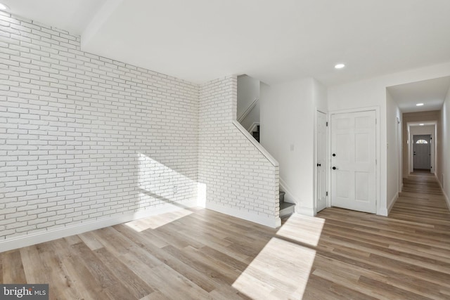 interior space featuring light wood-type flooring and brick wall