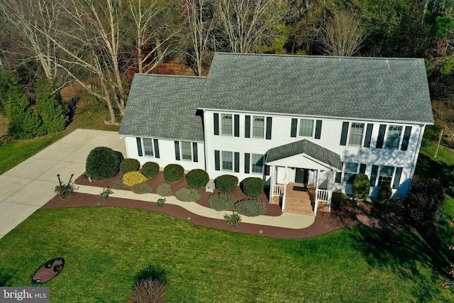 colonial-style house featuring a front lawn