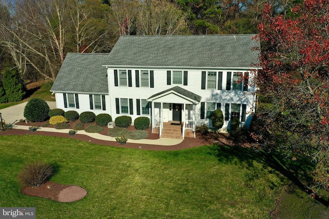 colonial inspired home with a front lawn