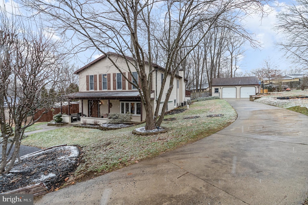 view of front property with a garage, an outbuilding, and a front lawn