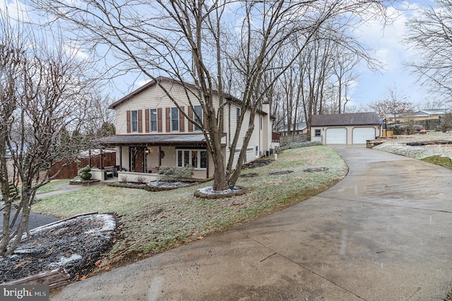 view of front property with a garage, an outbuilding, and a front lawn