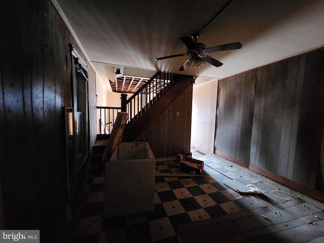 foyer entrance with wood walls and ceiling fan