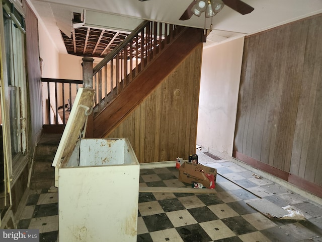 stairway with wood walls and ceiling fan