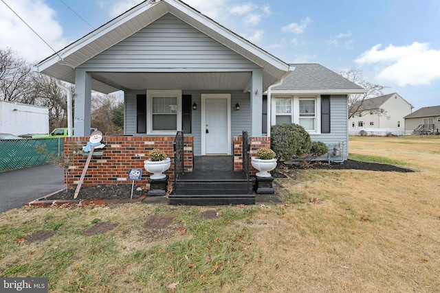 bungalow featuring a porch and a front lawn