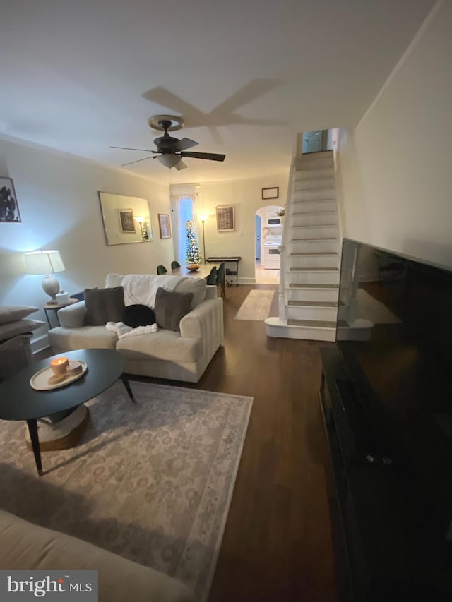 living room featuring ceiling fan and dark wood-type flooring