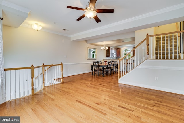 unfurnished room featuring ceiling fan with notable chandelier, light hardwood / wood-style floors, and ornamental molding