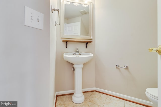 bathroom with toilet and tile patterned floors