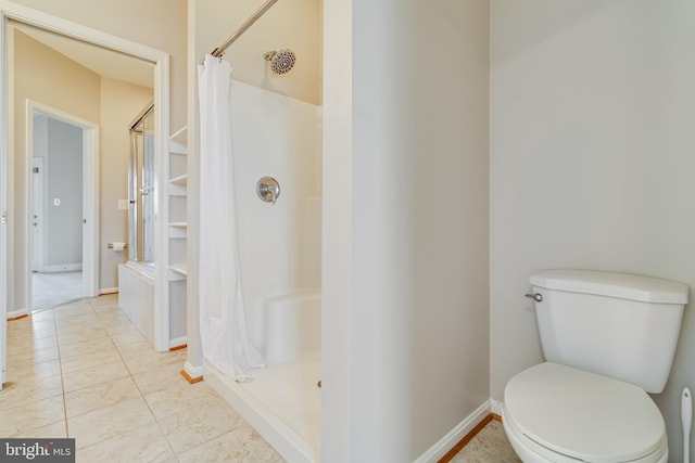 bathroom featuring tile patterned flooring, a shower with curtain, and toilet