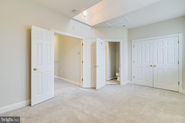 unfurnished bedroom with light colored carpet and a closet