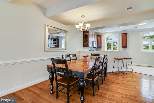 dining area featuring a chandelier, a healthy amount of sunlight, and light wood-type flooring