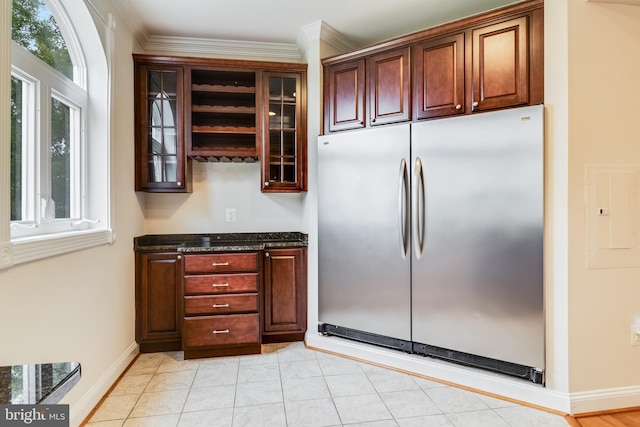 kitchen featuring electric panel, stainless steel refrigerator, crown molding, and dark stone countertops