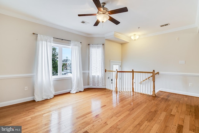 empty room with ceiling fan, ornamental molding, and light hardwood / wood-style flooring