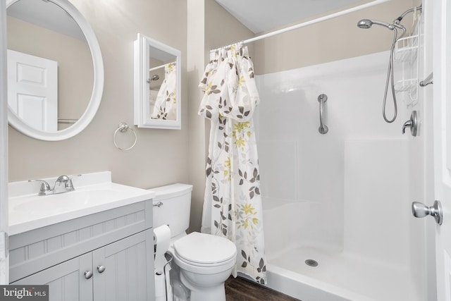 bathroom featuring hardwood / wood-style flooring, vanity, toilet, and walk in shower