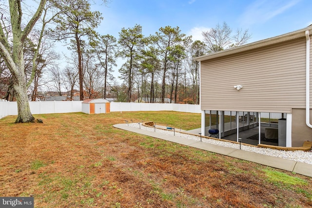 view of yard featuring a sunroom and a storage shed