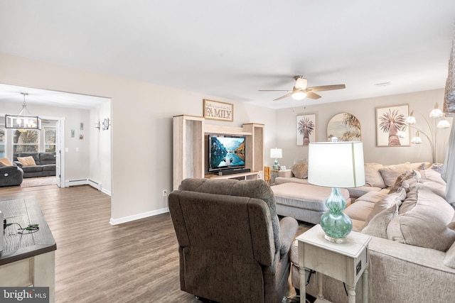 living room featuring wood-type flooring and ceiling fan with notable chandelier