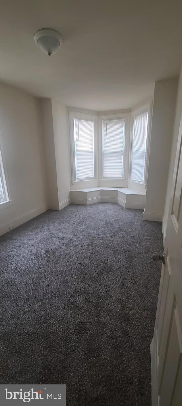 empty room featuring dark carpet