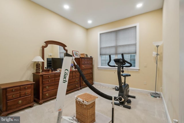 workout room featuring light carpet