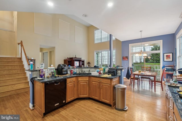 kitchen with pendant lighting, an inviting chandelier, sink, light hardwood / wood-style flooring, and black dishwasher