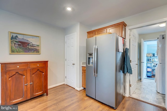 kitchen featuring stainless steel fridge, white fridge, and light wood-type flooring