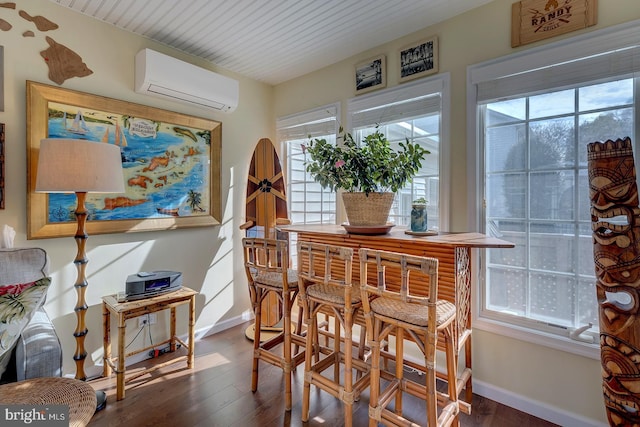 dining space with an AC wall unit and dark hardwood / wood-style flooring