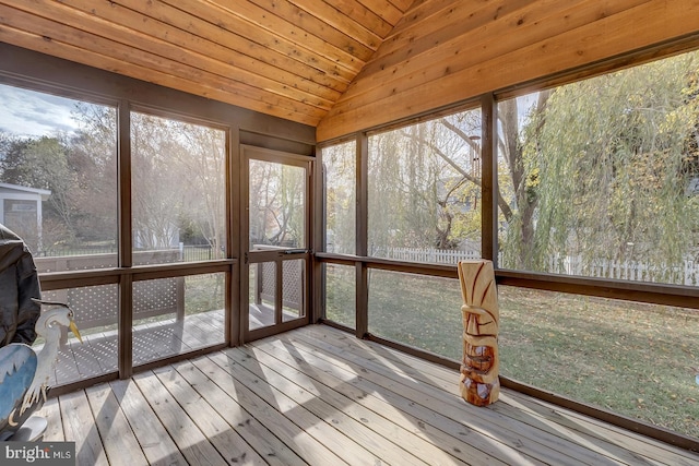 unfurnished sunroom featuring wooden ceiling, a healthy amount of sunlight, and lofted ceiling