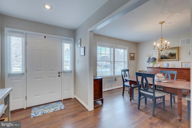 entryway featuring a healthy amount of sunlight, dark hardwood / wood-style flooring, and a chandelier