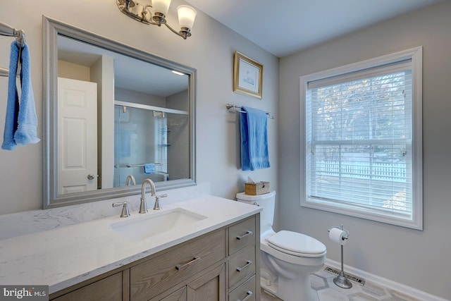 bathroom featuring tile patterned floors, vanity, a shower with shower door, and toilet