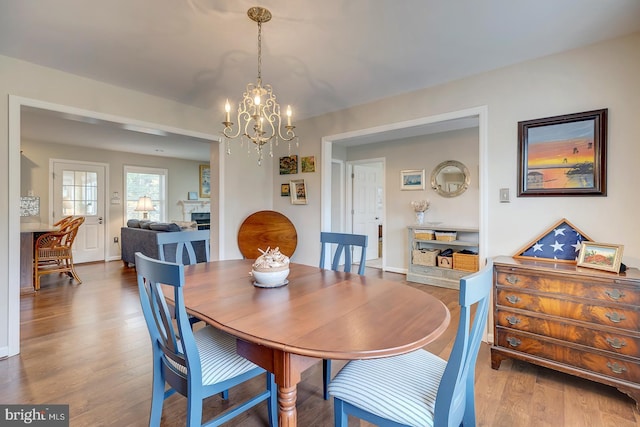 dining area featuring wood-type flooring and a notable chandelier