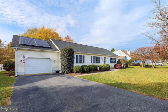 single story home featuring a front lawn, a garage, and solar panels