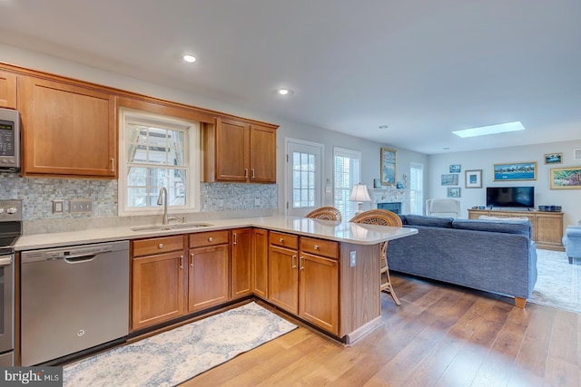 kitchen with kitchen peninsula, stainless steel appliances, plenty of natural light, and sink