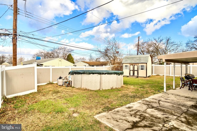 view of yard featuring a patio, a storage unit, and a covered pool