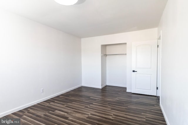 unfurnished bedroom with a closet and dark hardwood / wood-style flooring