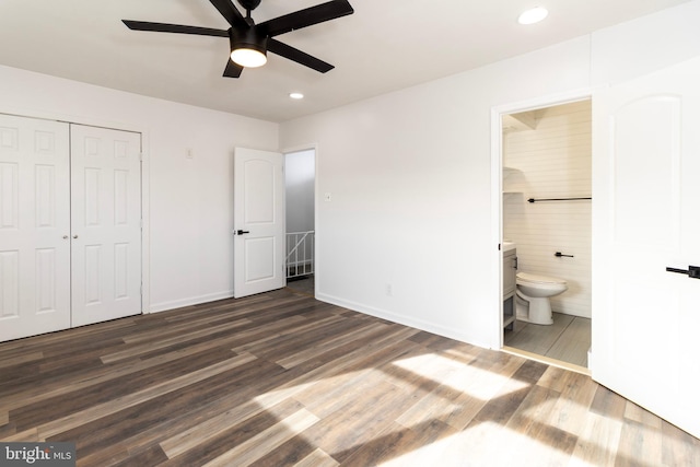 unfurnished bedroom featuring connected bathroom, ceiling fan, a closet, and dark wood-type flooring