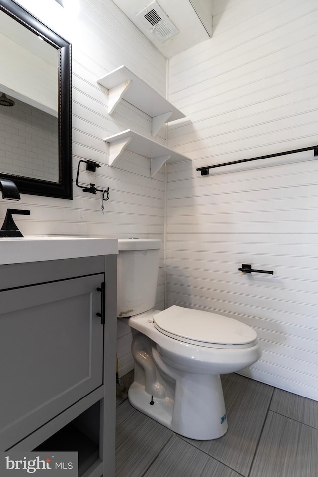 bathroom featuring tile patterned flooring, vanity, and toilet