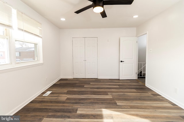 unfurnished bedroom with a closet, ceiling fan, and dark wood-type flooring