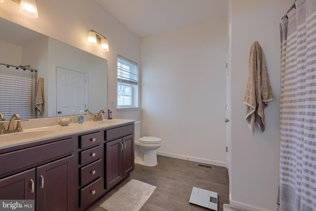 bathroom with vanity, toilet, and wood-type flooring