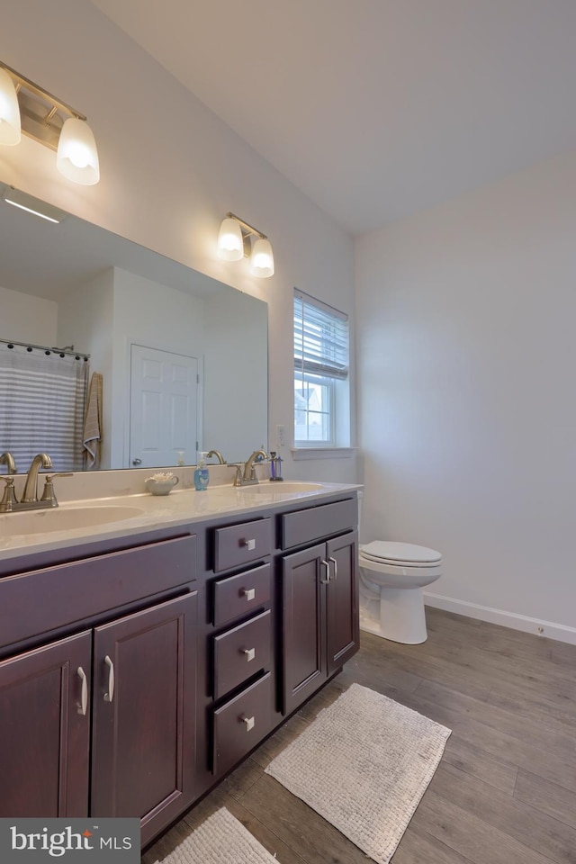 bathroom featuring toilet, vanity, a shower with shower curtain, and hardwood / wood-style flooring