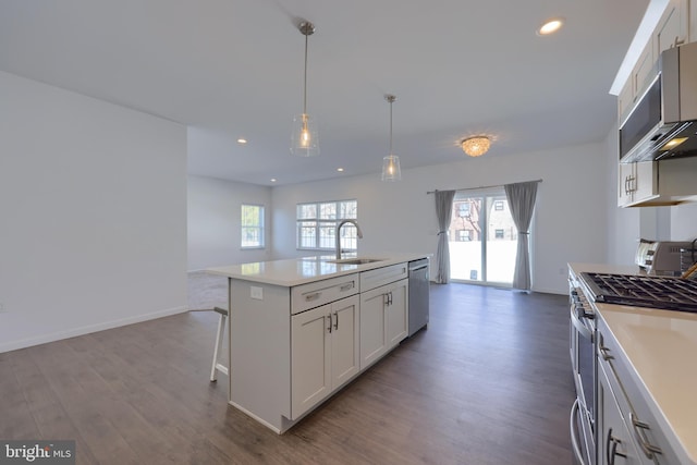 kitchen with white cabinetry, a center island with sink, stainless steel appliances, and plenty of natural light