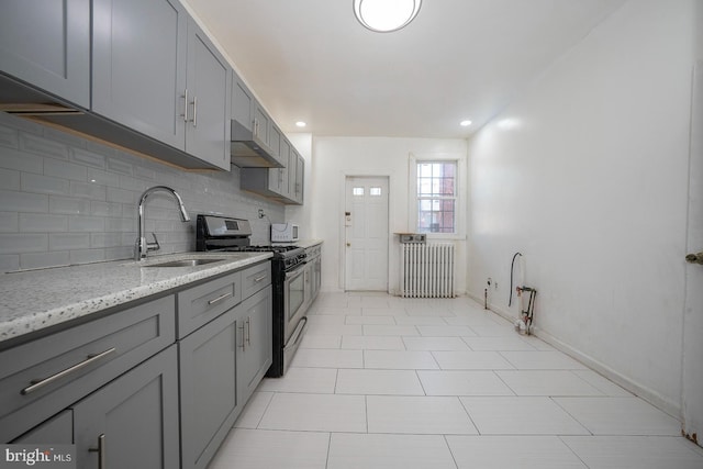 kitchen with gas stove, gray cabinets, sink, and radiator heating unit