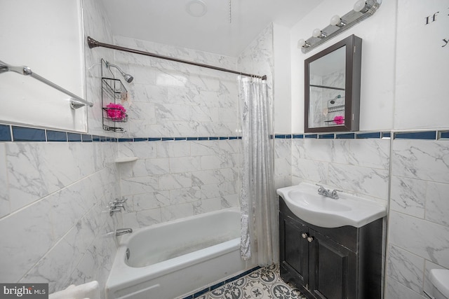 bathroom featuring vanity, shower / bath combination with curtain, and tile walls