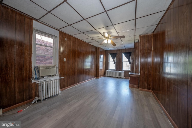 unfurnished room with hardwood / wood-style floors, radiator heating unit, and a paneled ceiling