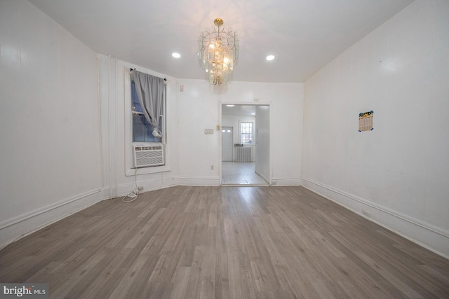 unfurnished room with a chandelier, hardwood / wood-style floors, and cooling unit