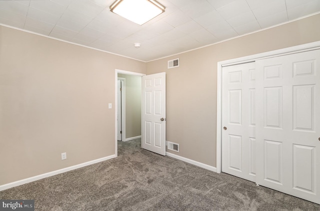 unfurnished bedroom featuring carpet, a closet, and crown molding