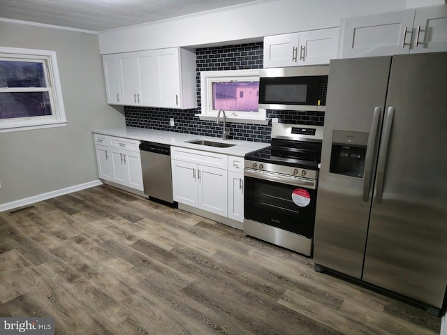 kitchen featuring backsplash, sink, dark hardwood / wood-style floors, appliances with stainless steel finishes, and white cabinetry