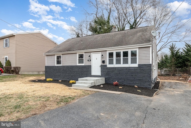 125 Evergreen St, Hummelstown, PA 17036 - view of front of home with stone siding, roof with shingles, a chimney, and asphalt driveway
