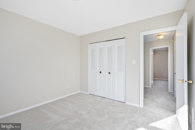 unfurnished bedroom with light carpet and a closet